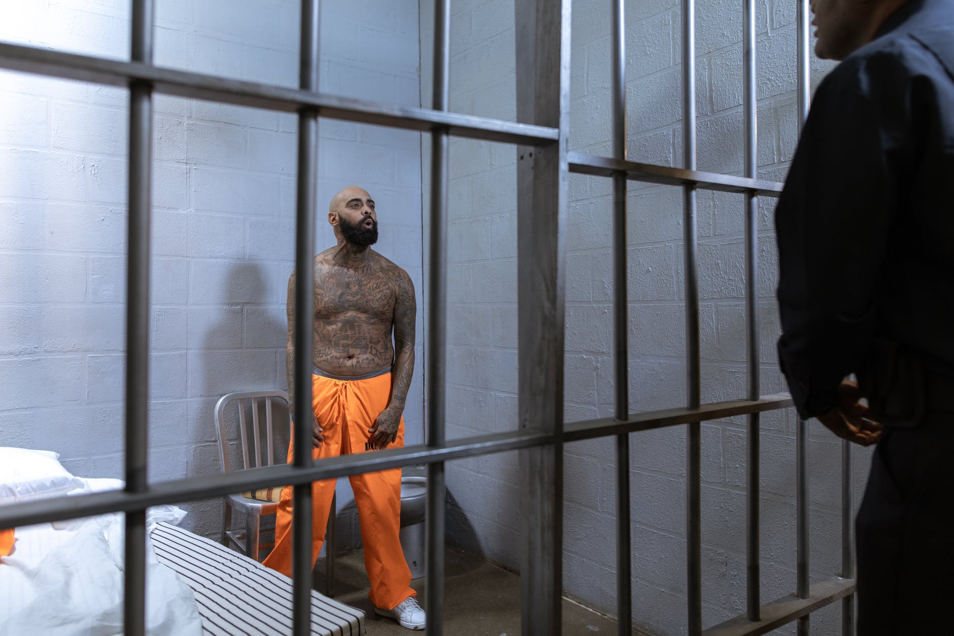 a shirtless prisoner full of body tattoos