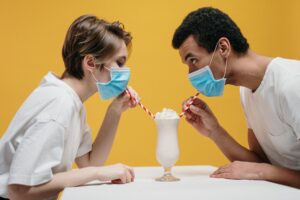 couple wearing face mask drinking milkshake
