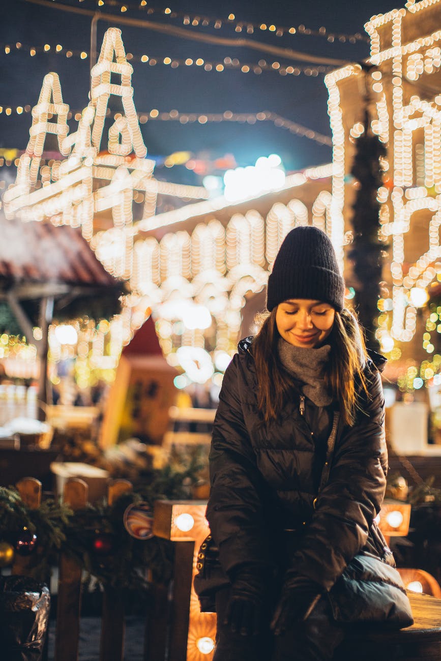 joyful modest woman on square in downtown at new year night