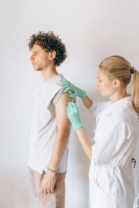 woman giving vaccine to a man
