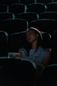 a woman sleeping in a movie theater