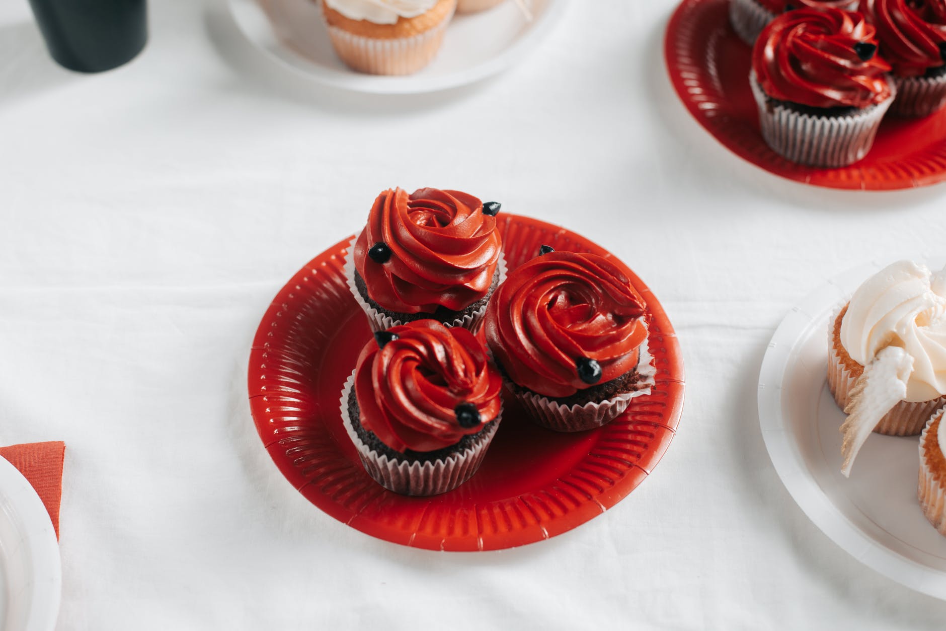 red icing chocolate cupcakes on red paper plate
