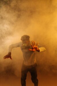 man wearing respirator surrounded by smoke