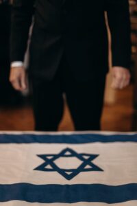 man standing next to the flag of israel