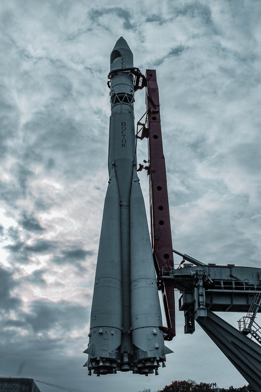 white and red space ship under cloudy sky