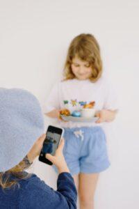 little girl taking a picture with a smartphone
