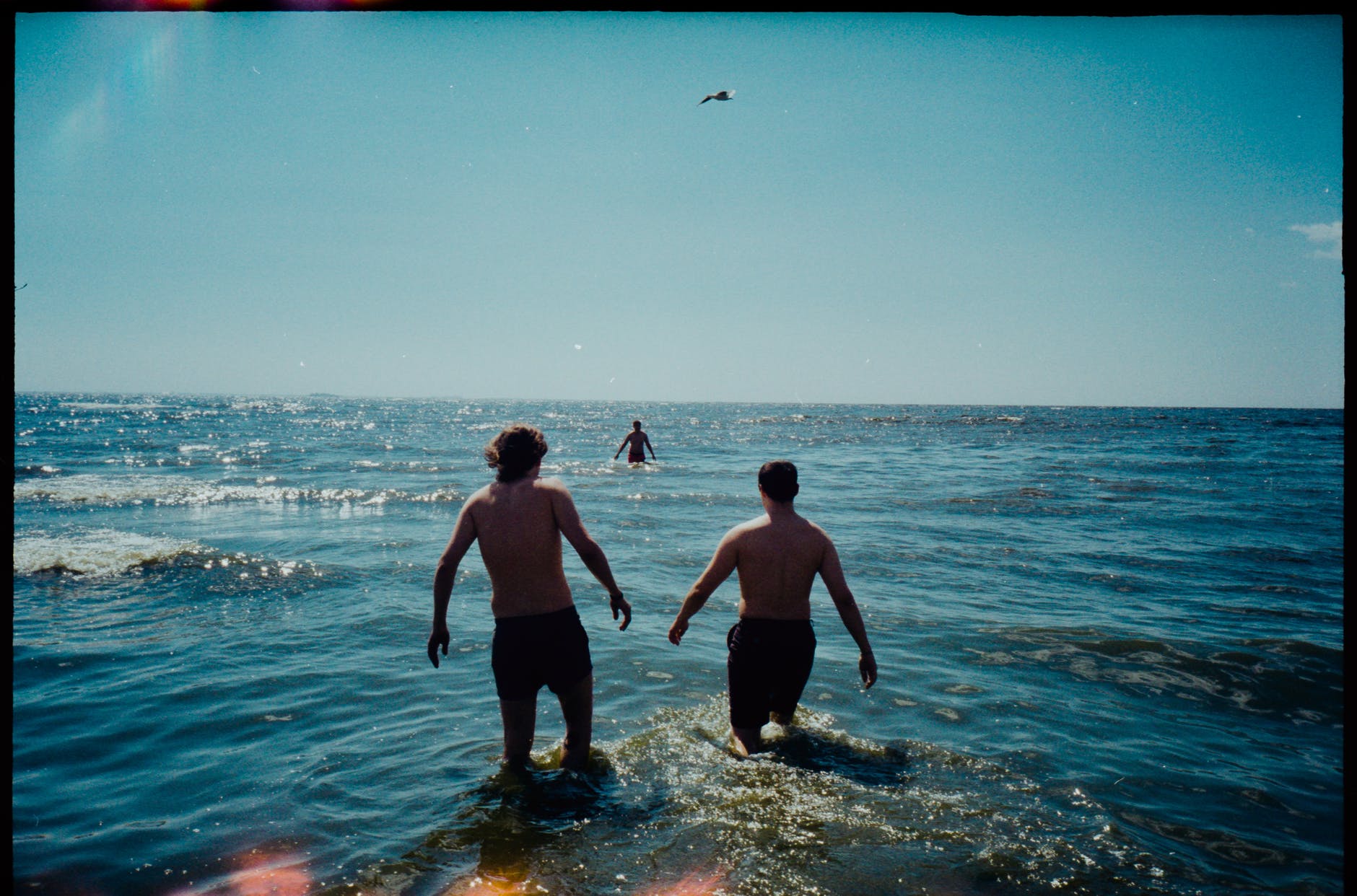 three men going into the sea