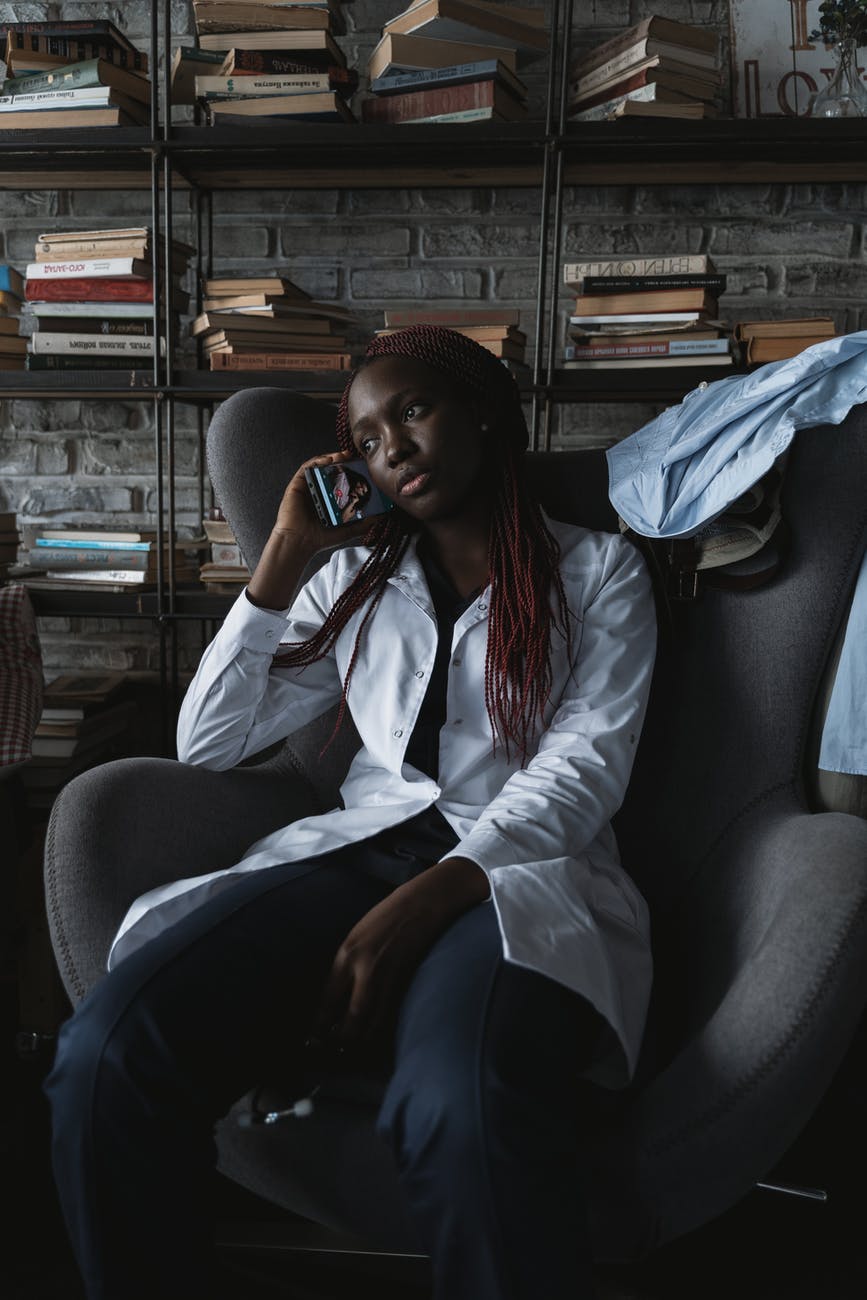 woman in white button up long sleeve shirt sitting on black leather armchair