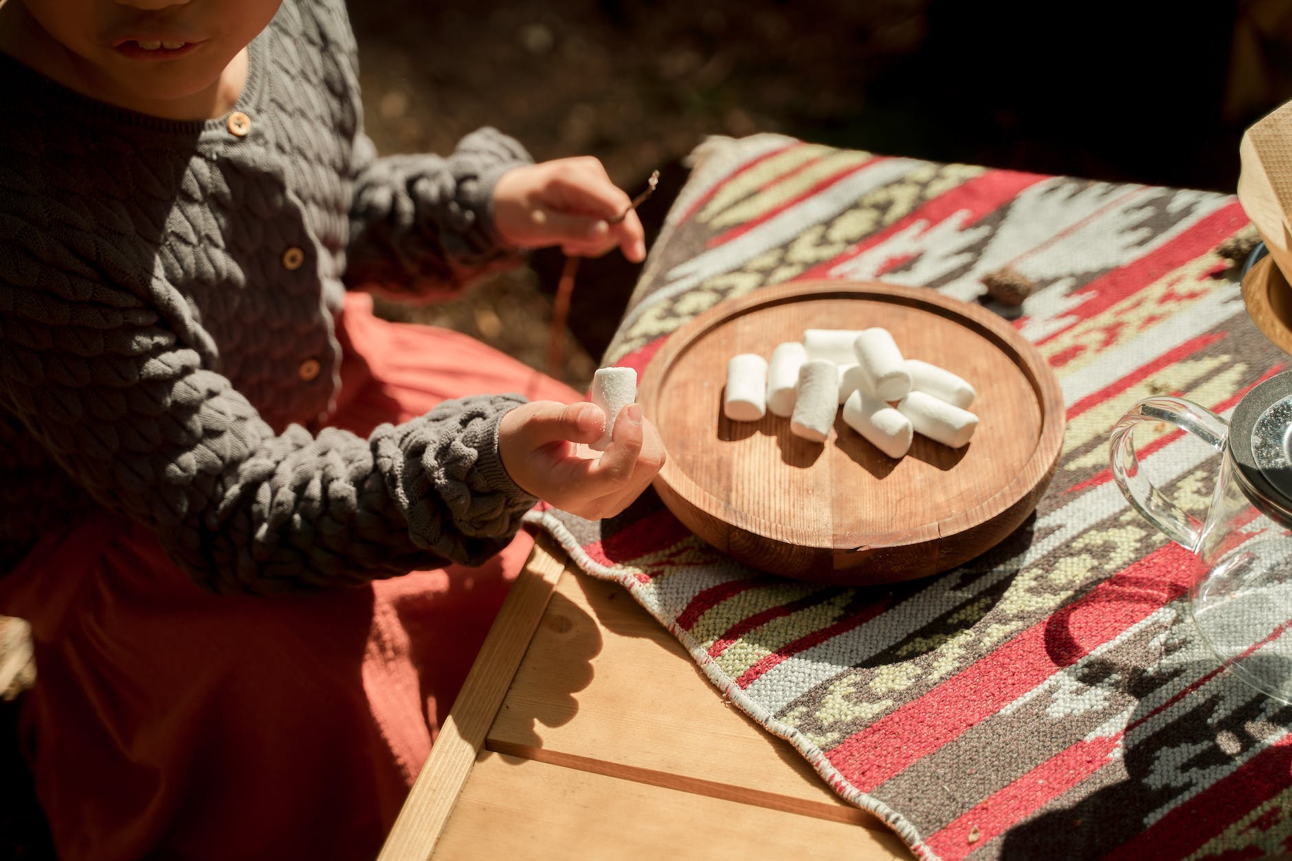 a girl holding a stick and a marshmallow