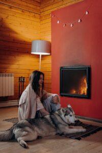 woman with her dog near the fireplace