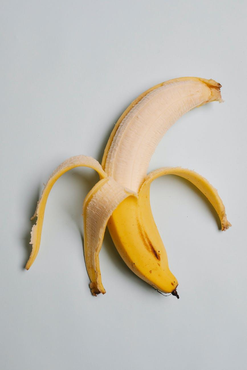fresh peeled banana on white surface