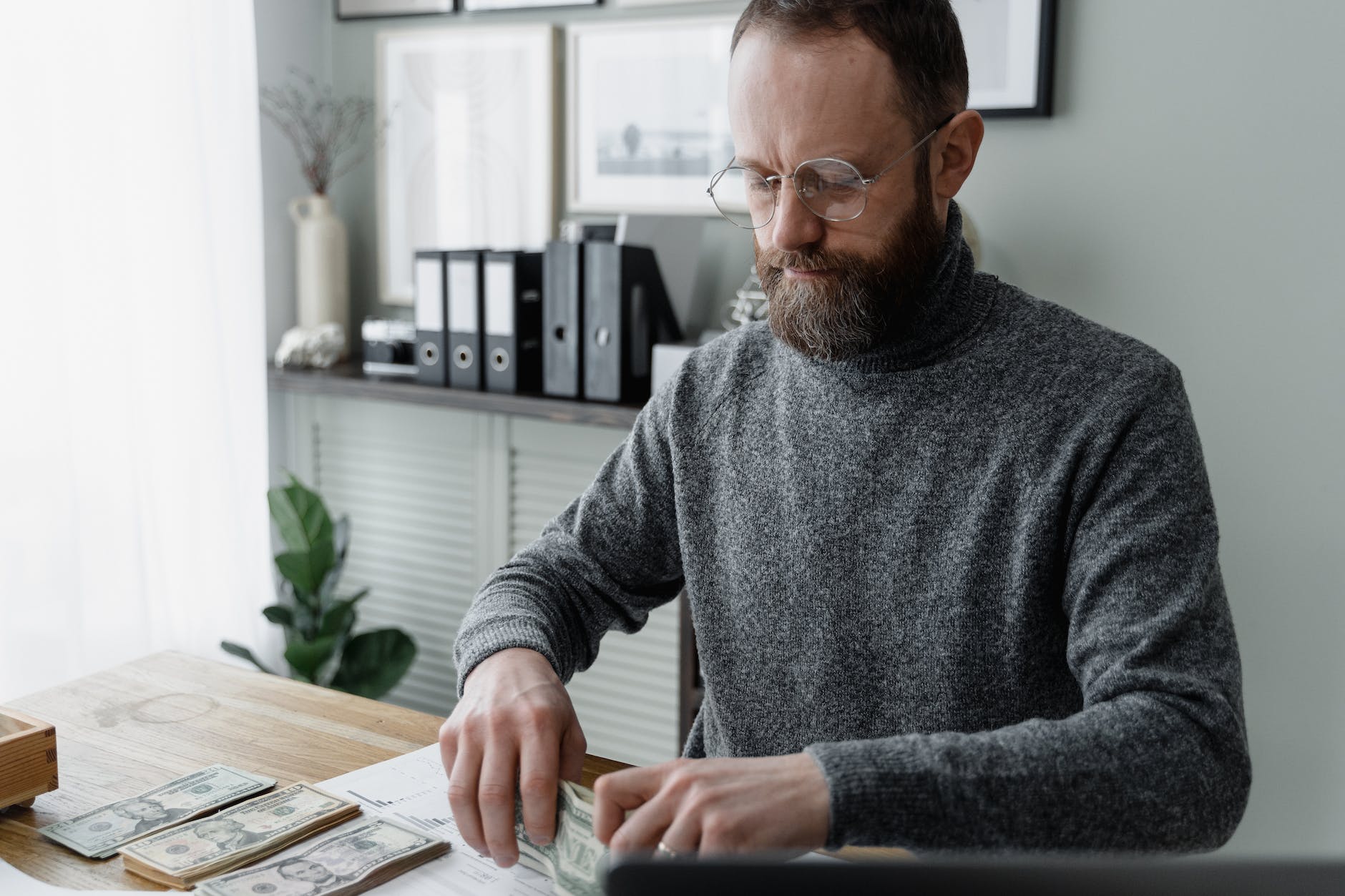 man in gray sweater wearing eyeglasses
