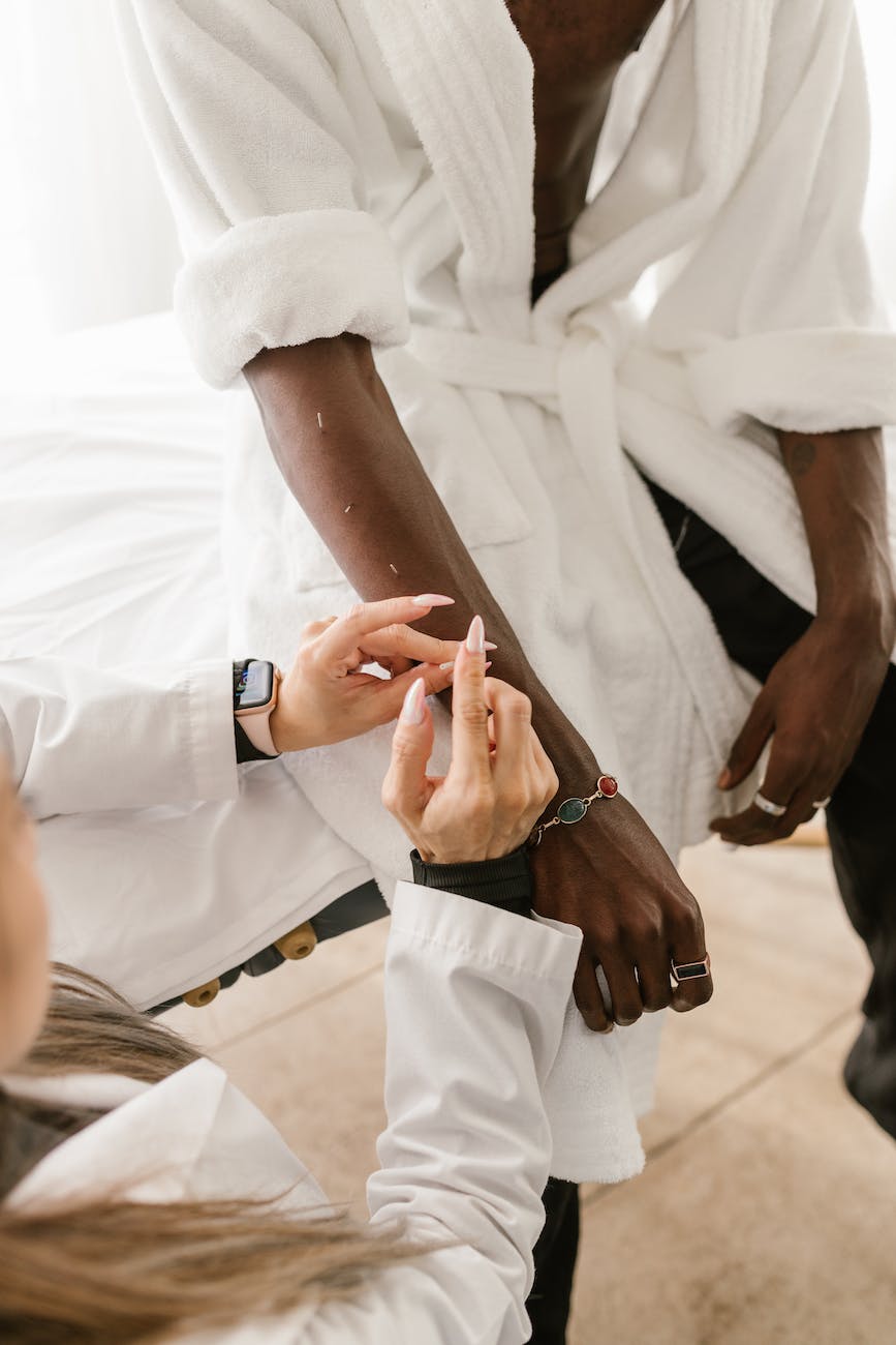 a doctor putting needles on a man s arm
