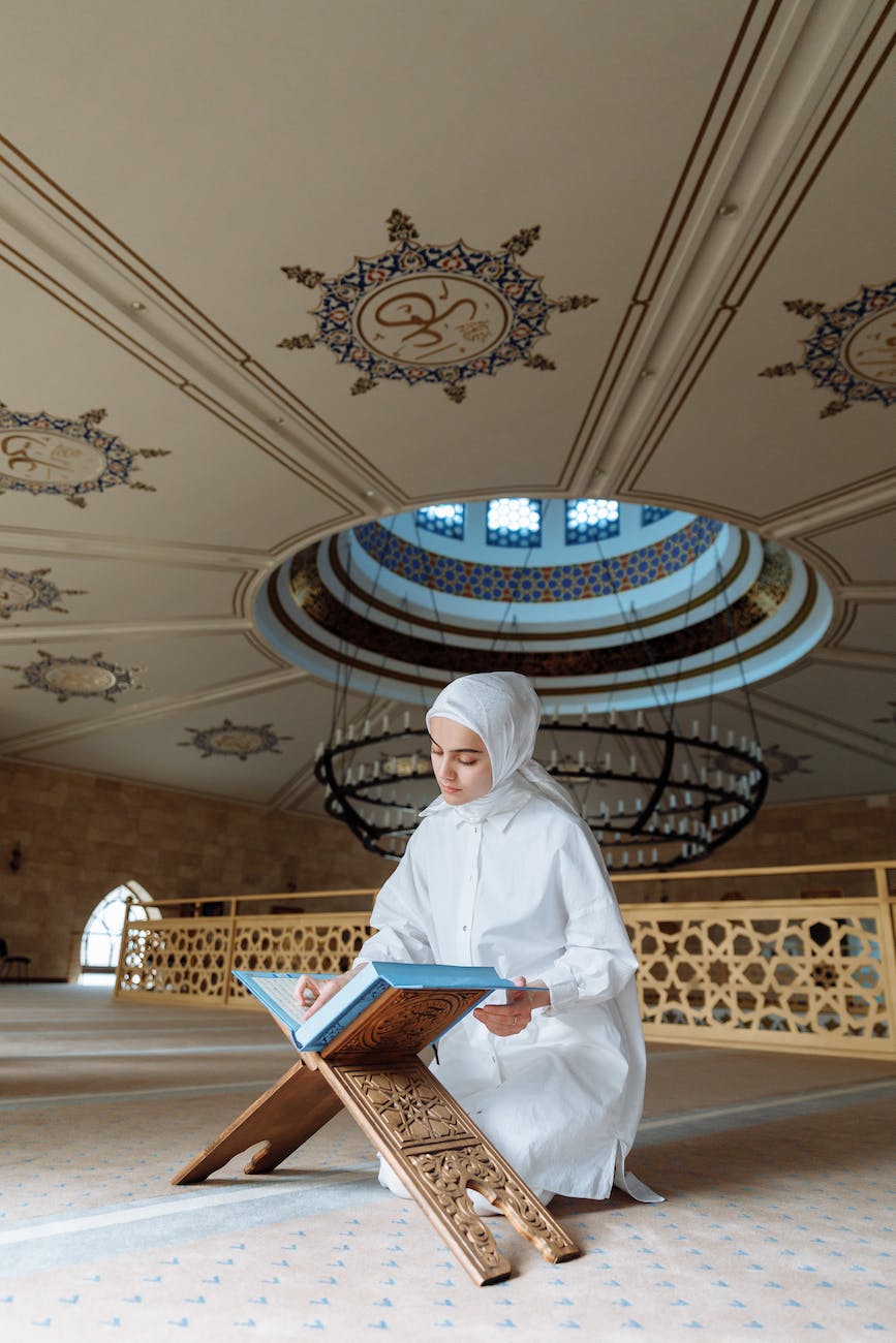 a woman in white hijab reading a book