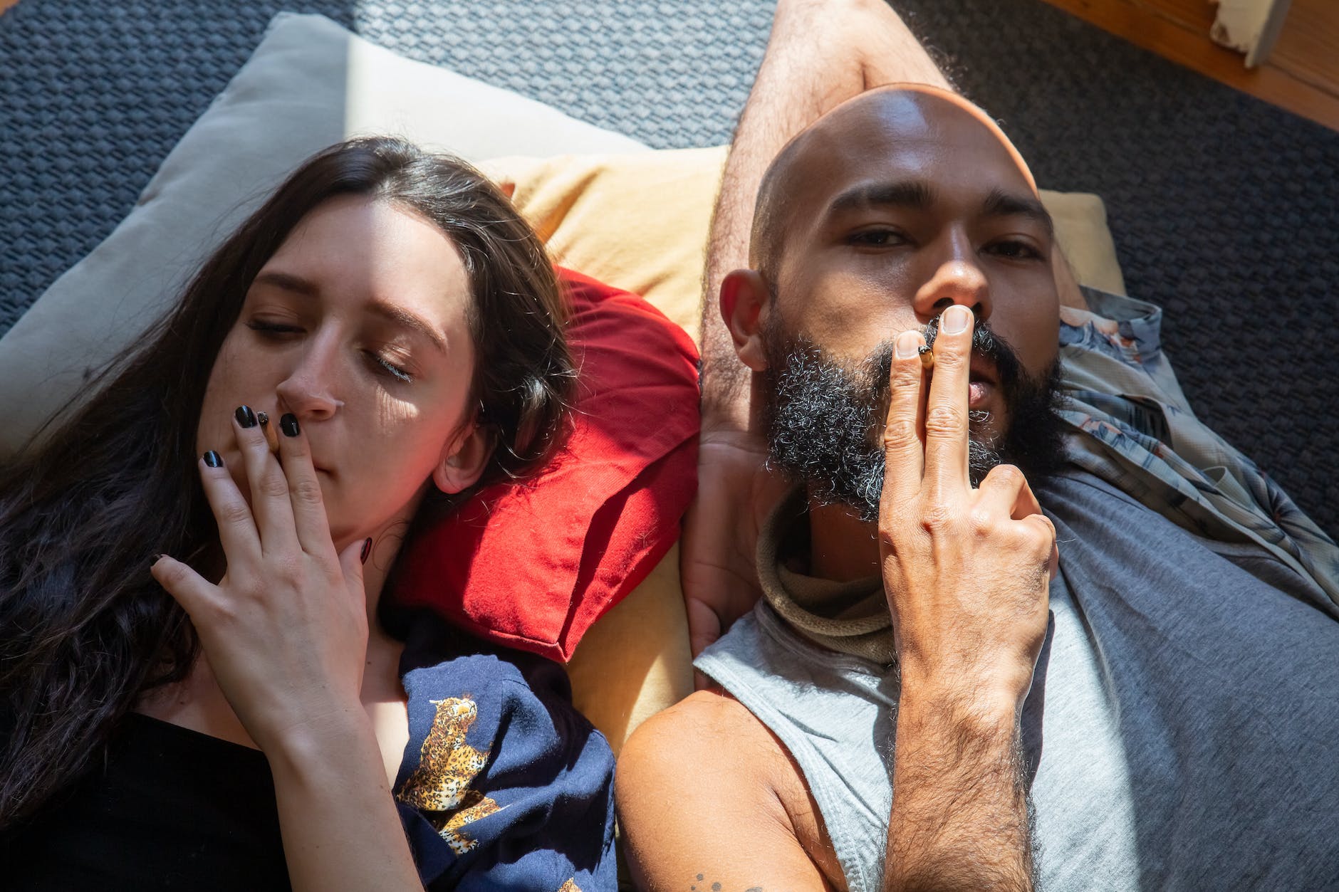 a couple smoking joints while lying on the floor
