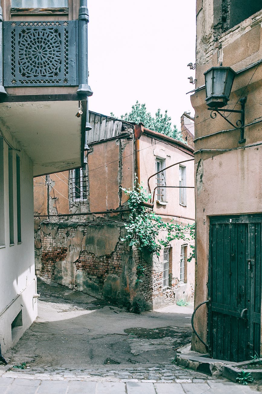 narrow pedestrian street between shabby residential buildings