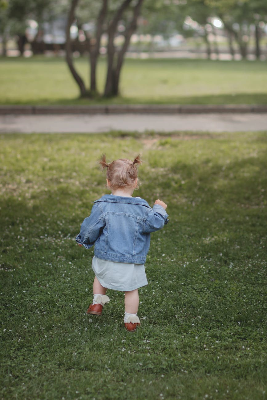 girl in blue dress running on green grass field