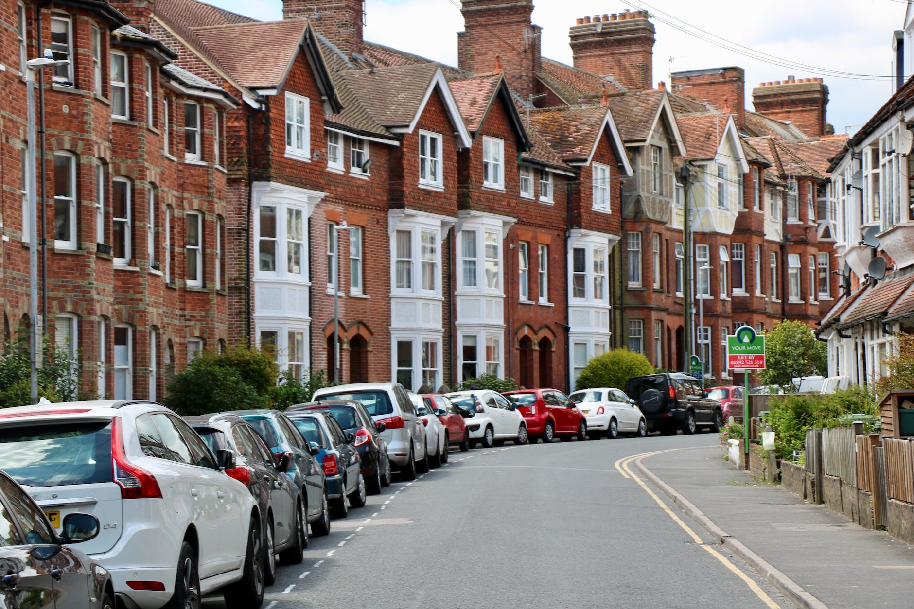 photo of vehicles on road near houses