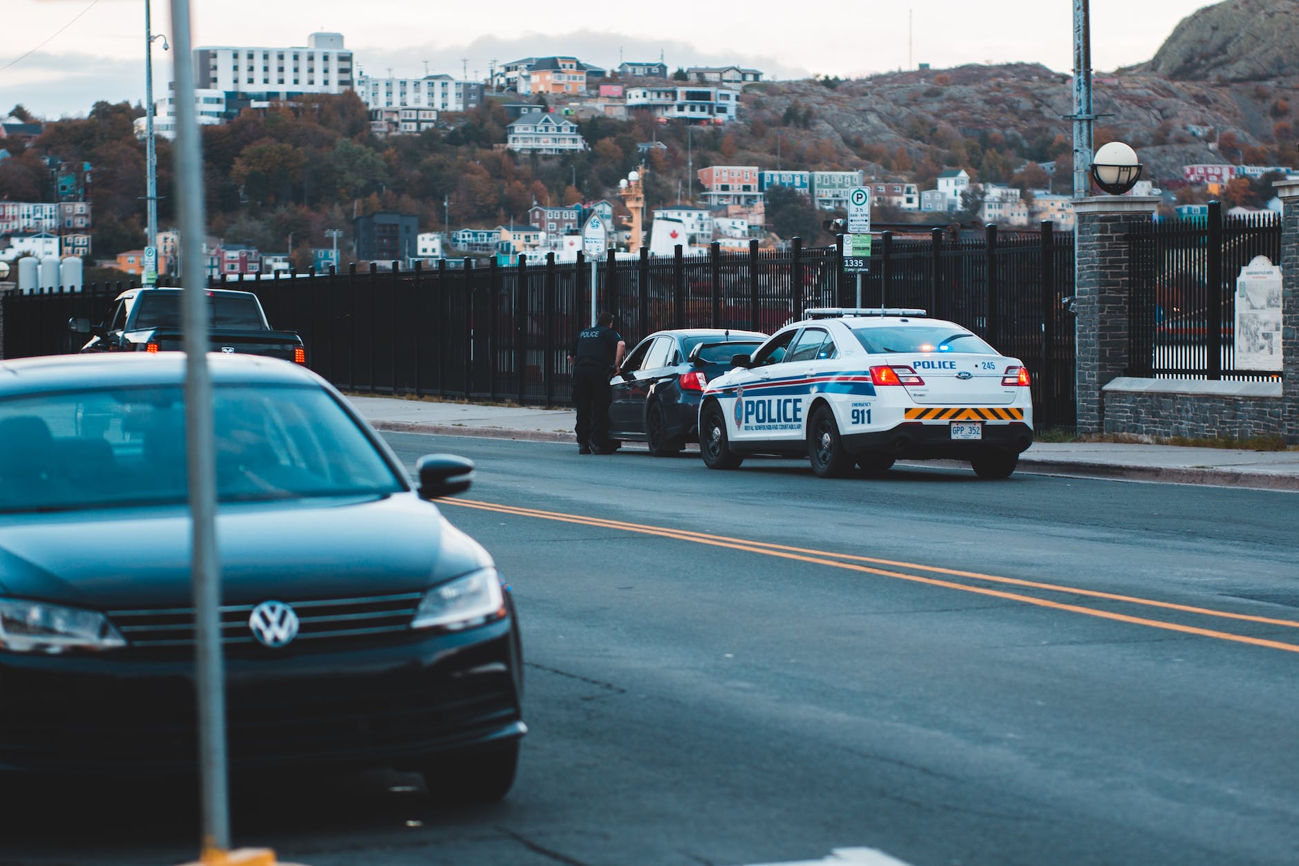 anonymous policeman checking car on street