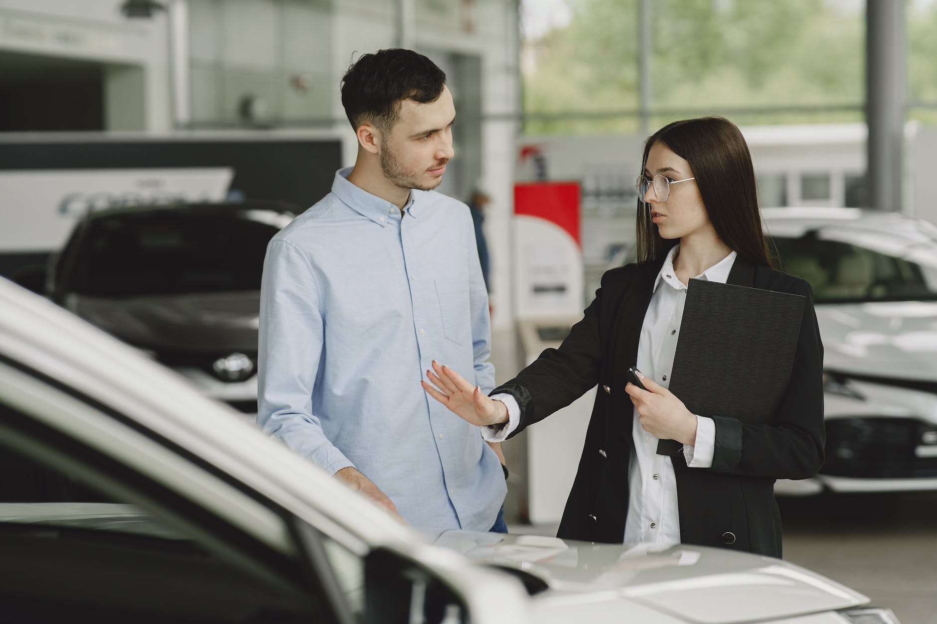 woman selling car to client in salon