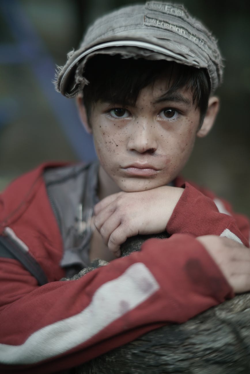poor ethnic boy with freckles on street