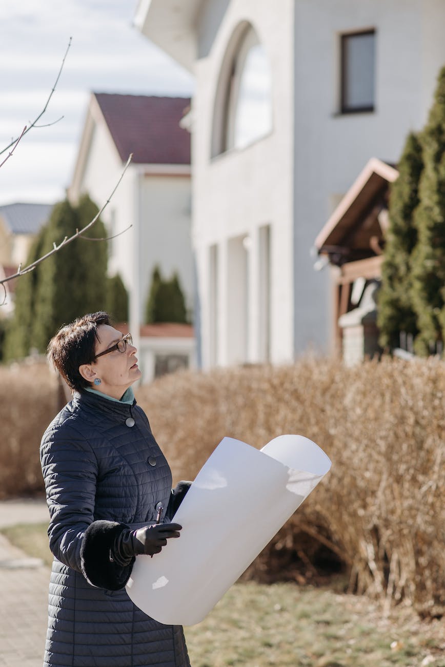 woman in blue coat holding white paper