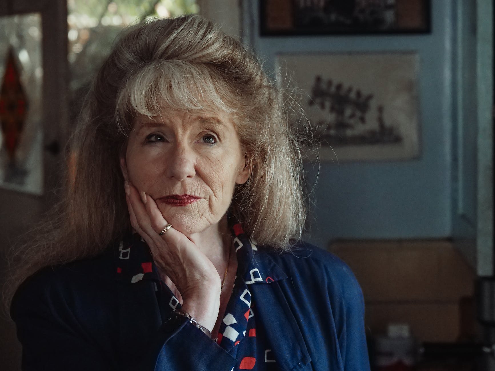 an elderly woman with her hand on her chin