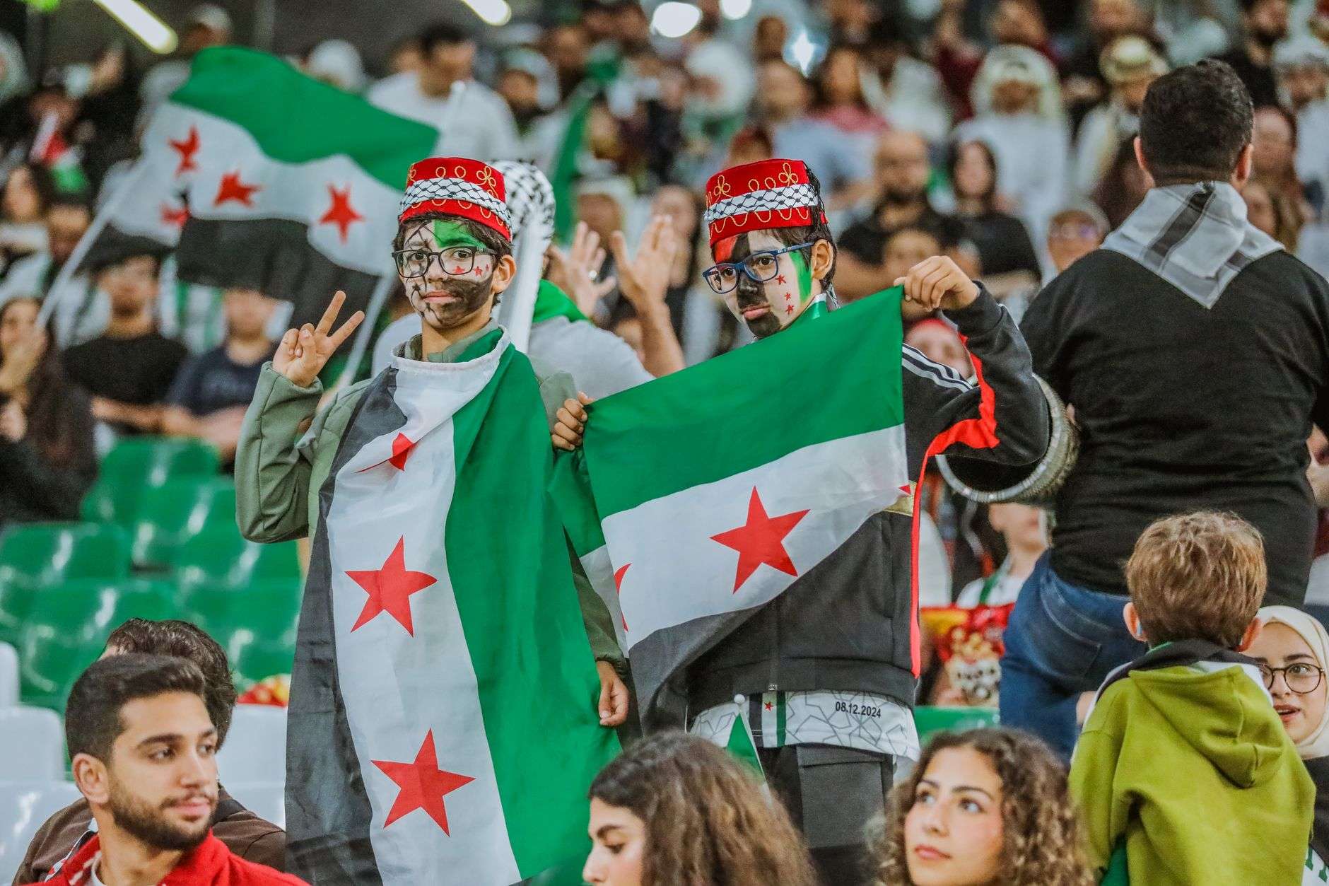 syrian fans celebrating at a sports event in doha