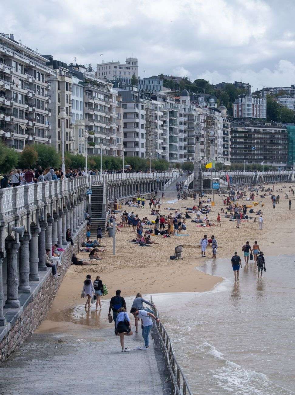 people on beach in city