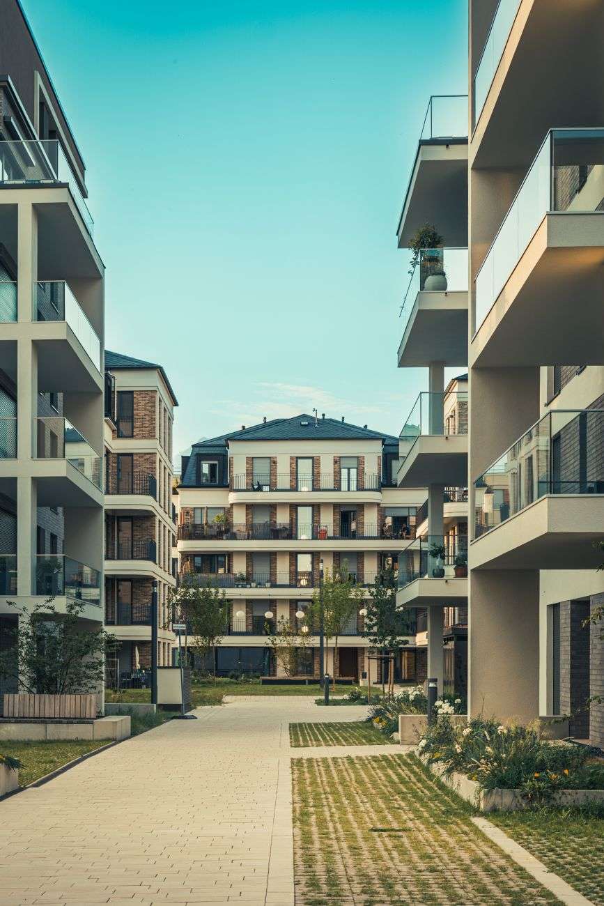 a walkway in front of two apartment buildings
