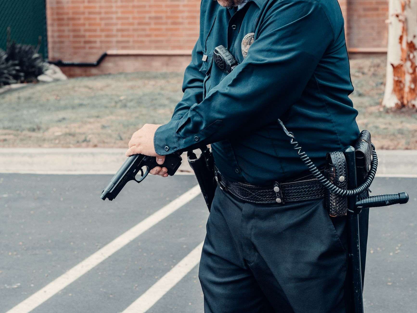 a person in police uniform holding black gun