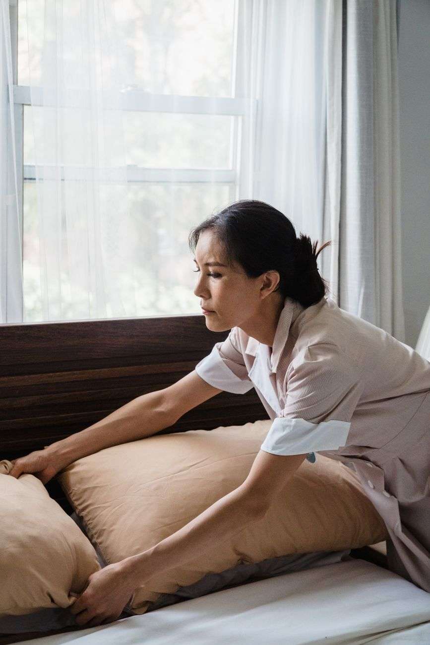 woman cleaning bedroom