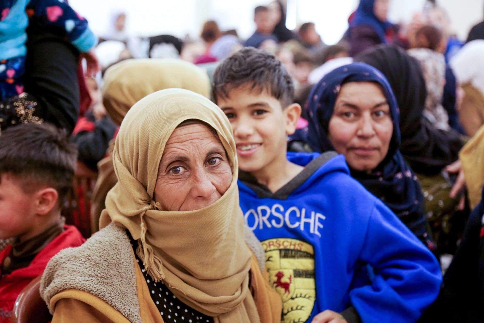 a mature woman wearing brown hijab near a crowd