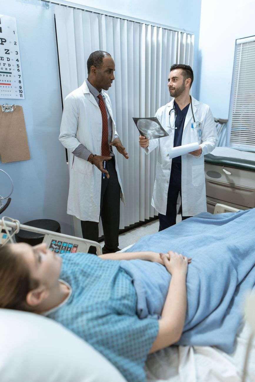 doctors talking beside the patient
